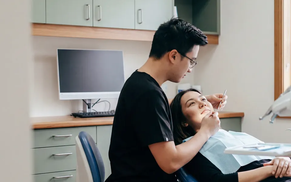 An Enhanced Dental Studios dentist treating a numbed tooth for a patient in the chair.