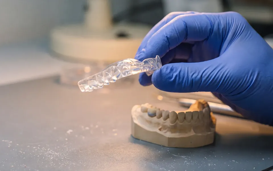 A custom sleep device being fitted to a model at the Enhanced Dental Studios lab.