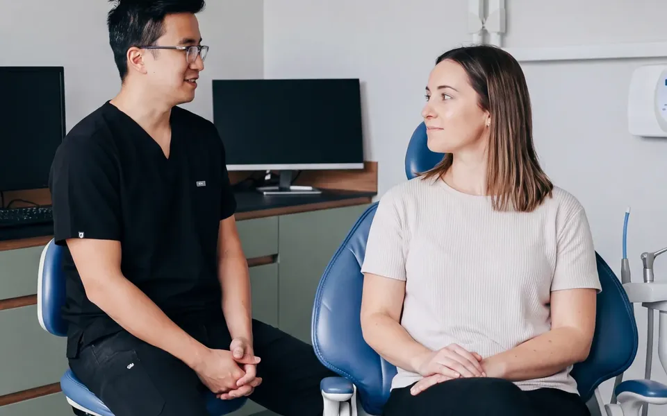 An Enhanced Dental Studios dentist talking a patient through her options before treatment.