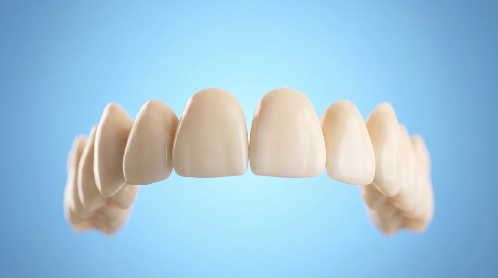 A row of even upper front teeth, all whole and matched, seen from a low angle