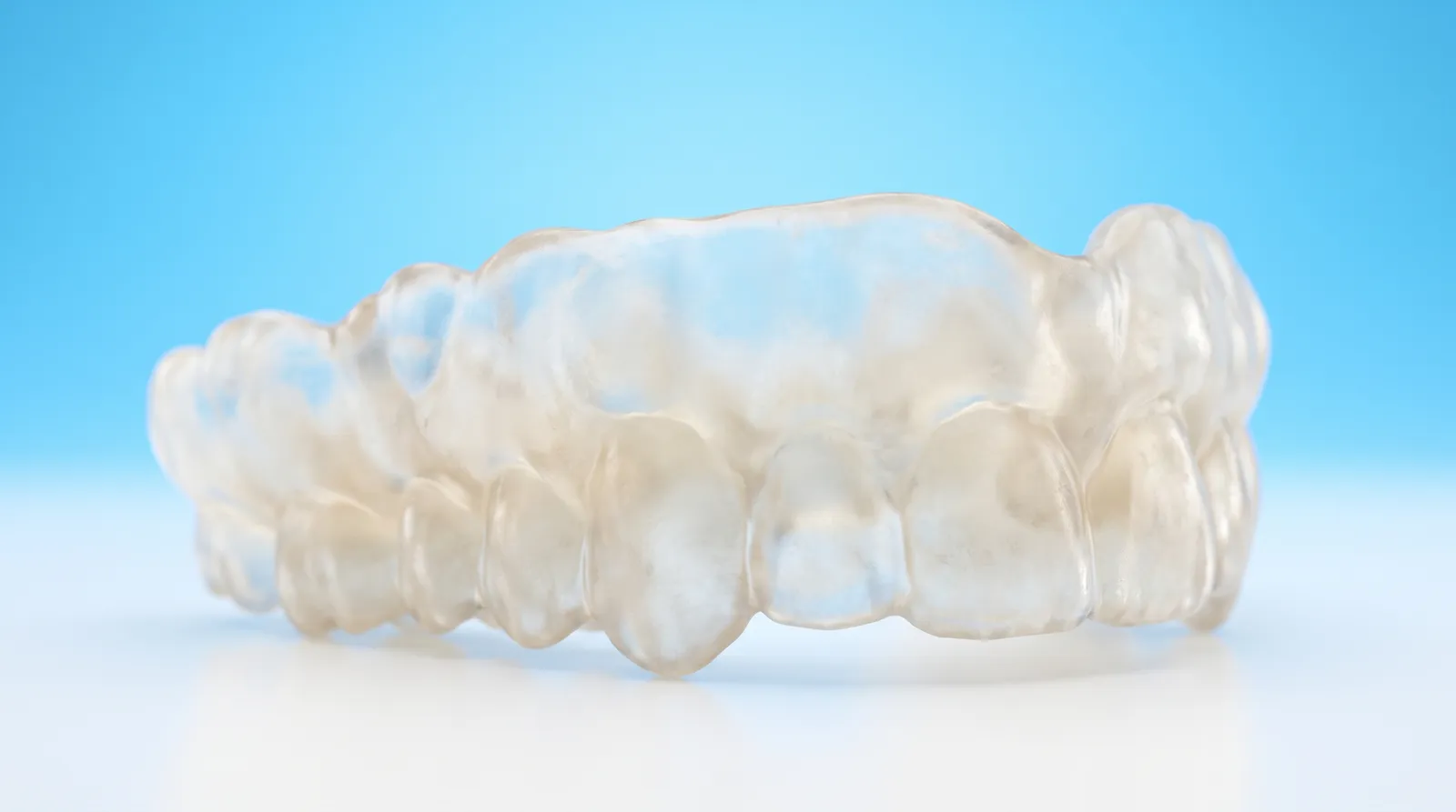 A thick bulky clear mouthguard with uneven lumpy edges, resting on its own