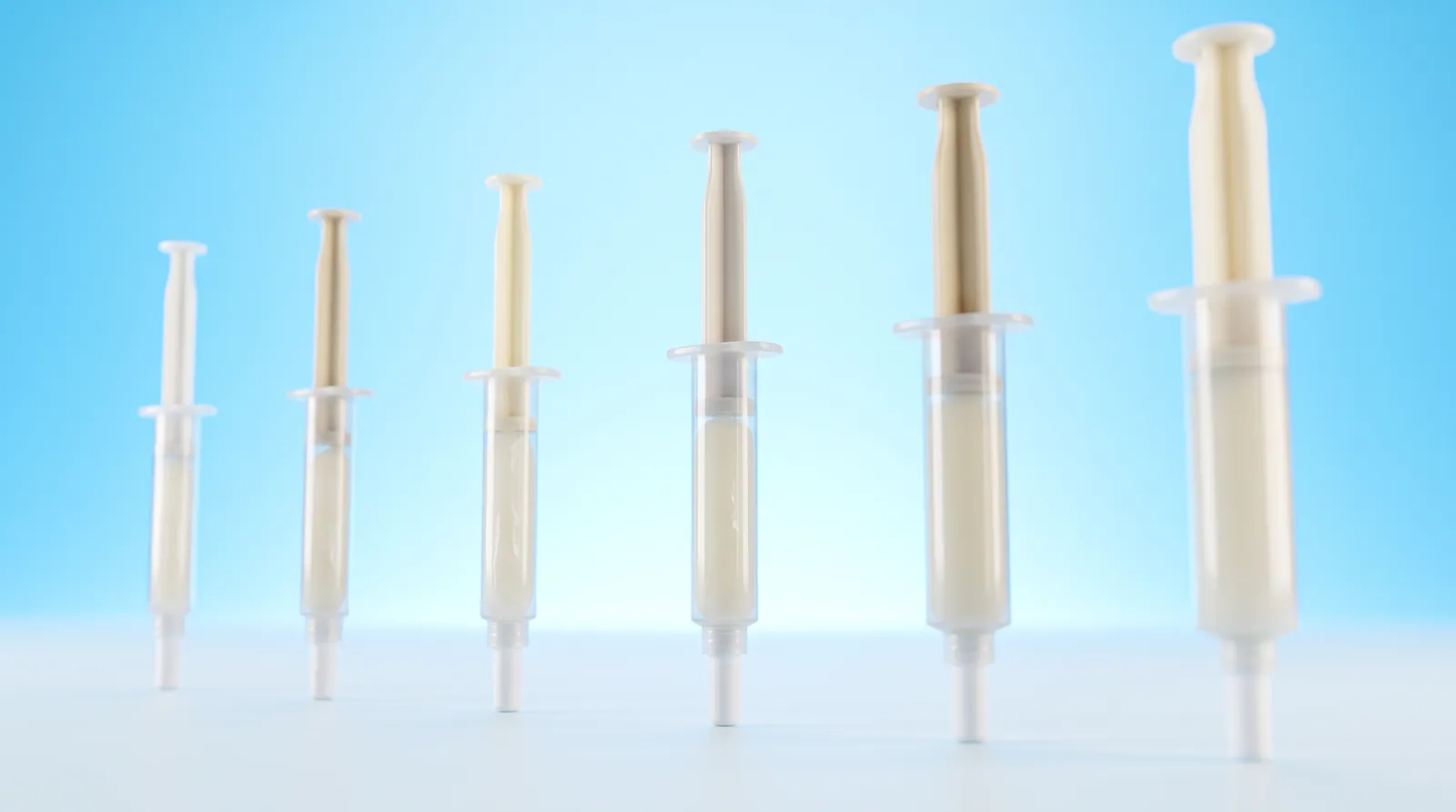 Several whitening gel syringes lined up in a row, each one a slightly different size